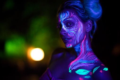 Night portrait of a beautiful girl with fluorescent body paint.