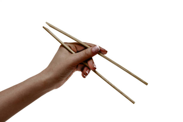 istock African female hand holds chopsticks on a white background. 1136598834