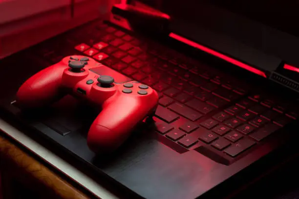 Photo of Gamepad on computer keyboard in the dark. Video game controllers