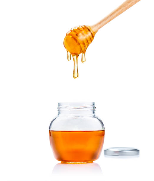 유리 항아리와 꿀에서 나무 꿀이 퍼에서 아래로 떨어지는 꿀 흰색 배경에 복사 공간 - syrup jar sticky isolated objects 뉴스 사진 이미지