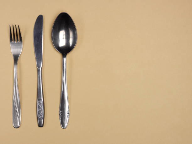 istock Stainless steel fork, knife and spoon on yellow background with copy space 1136605203