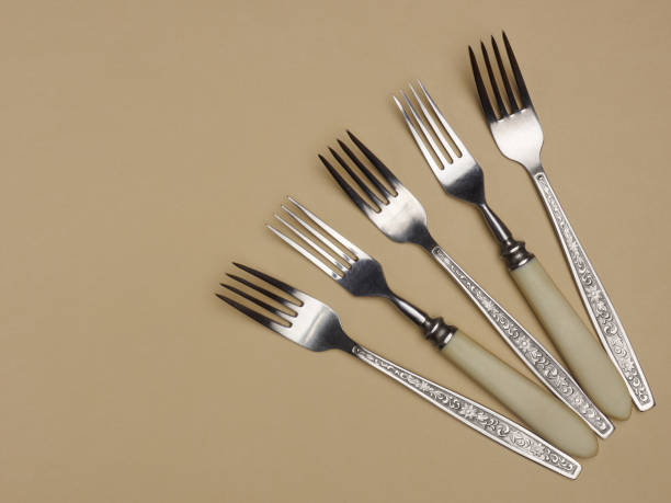 istock Five stainless steel forks on a yellow background with copyspace 1136606295