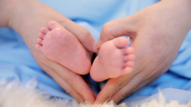 Newborn feet in mom hands