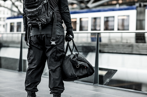 Dark hooded male terrorist like figure at urban city public transport hub