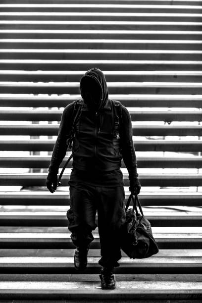 istock Dark hooded  figure in empty urban surroundings 1136608228