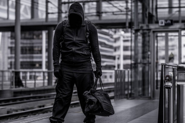 istock Dark hooded figure in empty urban surroundings 1136608358