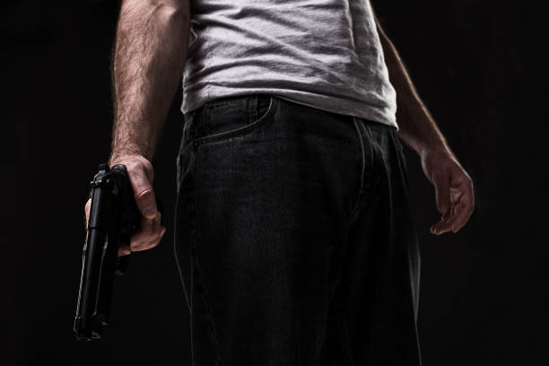 istock Killer with gun on black background at the studio 1136608627