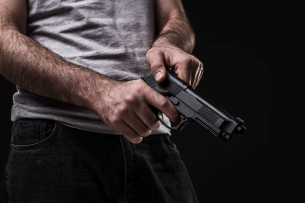 istock Killer with gun on black background at the studio 1136608630