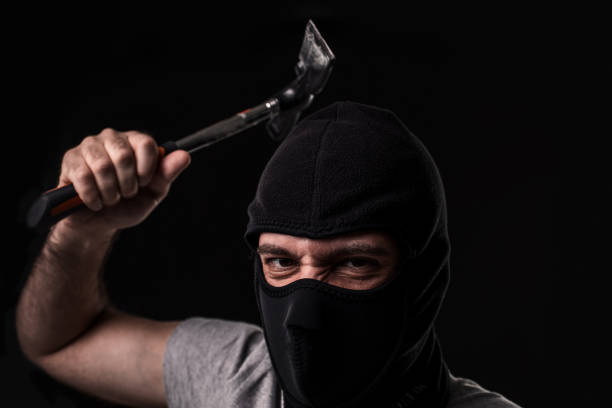 istock Criminal in T-shirt and balaclava with hammer 1136608635