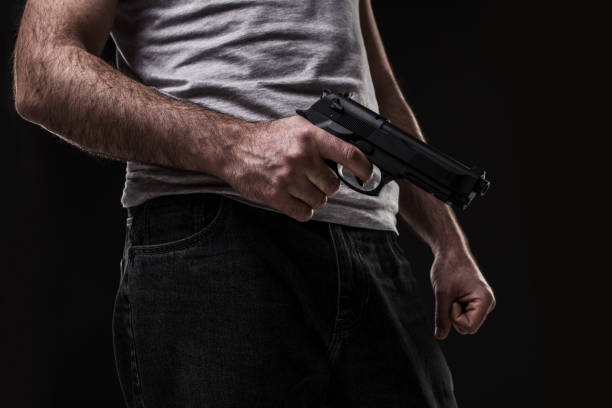 istock Killer with gun on black background at the studio 1136608644