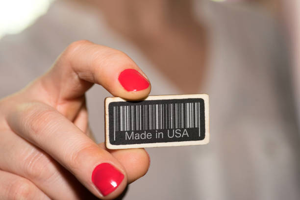 a woman and a sign with a barcode and slogan made in usa - buy usa american culture made in the usa imagens e fotografias de stock