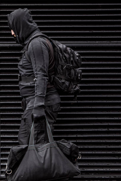 istock Dark hooded figure in empty urban surroundings 1136609947
