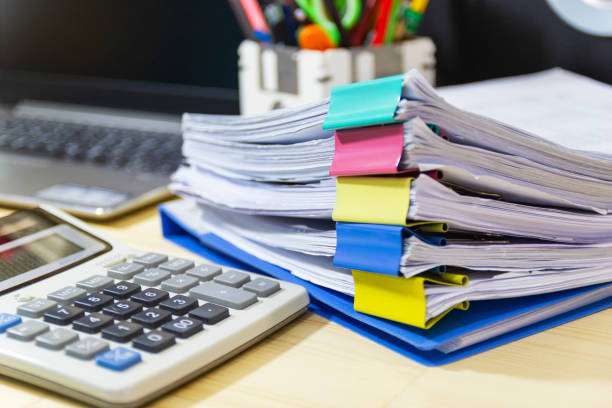 istock file folder and Stack of business report paper file on the table in a work office 1136610023