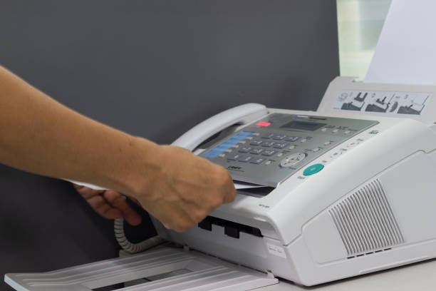 istock hand man are using a fax machine in the office Business concept 1136610170