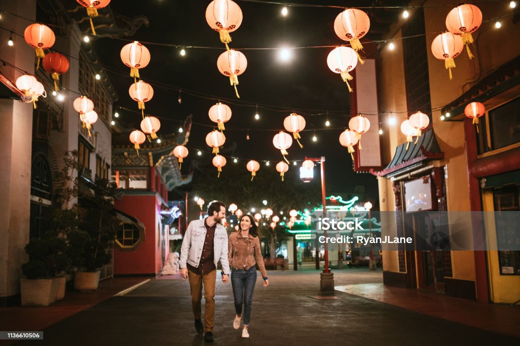 Happy Couple Exploring Chinatown in Downtown Los Angeles At Night A smiling Caucasian man and woman have fun together on the streets of Chinatown in L.A. California on a warm evening, exploring the cities night life.  Bright traditional lanterns illuminate the scene. City Of Los Angeles Stock Photo