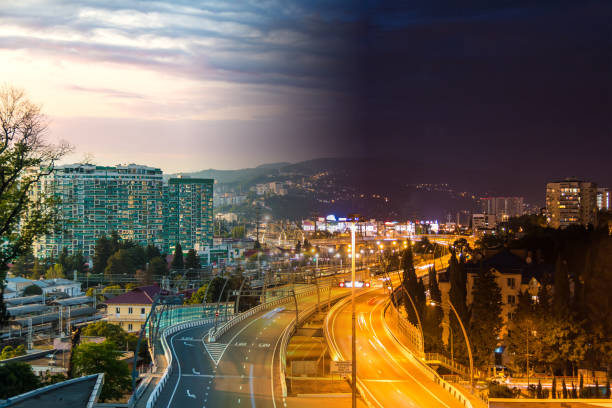 Time-lapse collage of day to night transition. Aerial view of city, mountains and Doubler of Kurortnyy Prospekt highway, Sochi, Russia