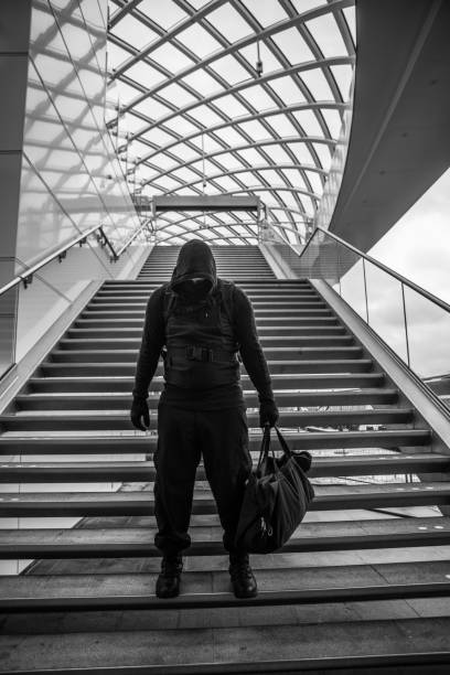 istock Dark hooded  figure in empty urban surroundings 1136610695