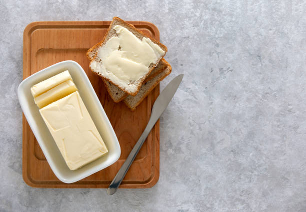 Butter or spread on a kitchen table, view from above Butter or spread is in white butter-dish standing on a kitchen table and sandwich served on board ready to eat, view from above, space for a text butter photos stock pictures, royalty-free photos & images