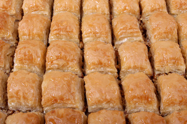 istock Baklava with walnut with a large table tray and a white striped from a close angle 1136611398