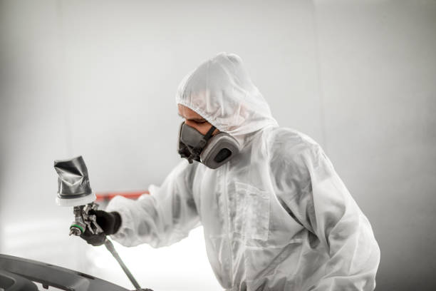 istock Professional car painter blasting a car part with a base coat paint in a workshop 1136614348