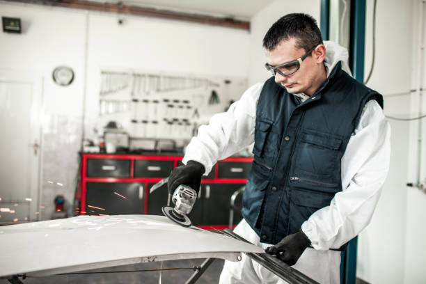 istock Car repairman using an angle grinder to grind a damaged car part 1136614682