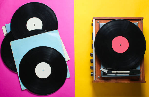 istock Retro style viny player and vinyl records with covers on a colored paper background. Pop culture, Top view 1136614810