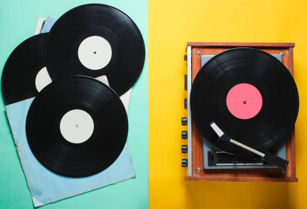 istock Retro style vinyl record player and vinyl records with covers on a colored paper background. Pop culture, Top view 1136614832