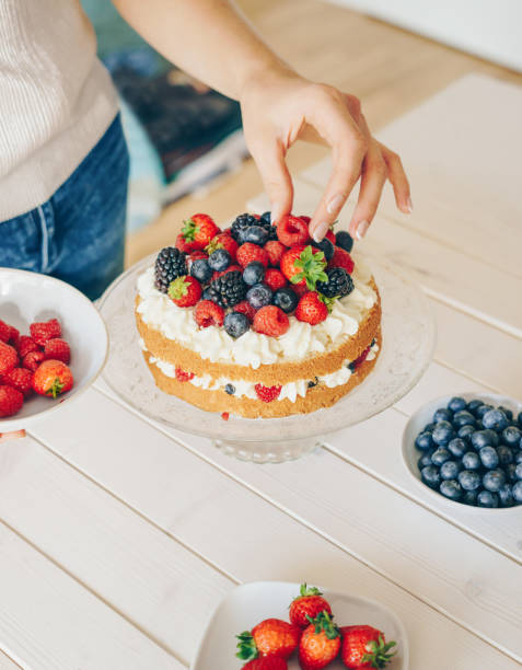 Woman decorating a berry cake