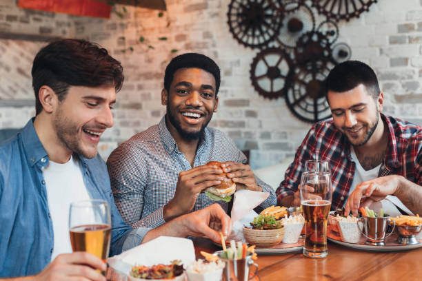 istock Three men enjoying burgers and beer in bar 1136617590