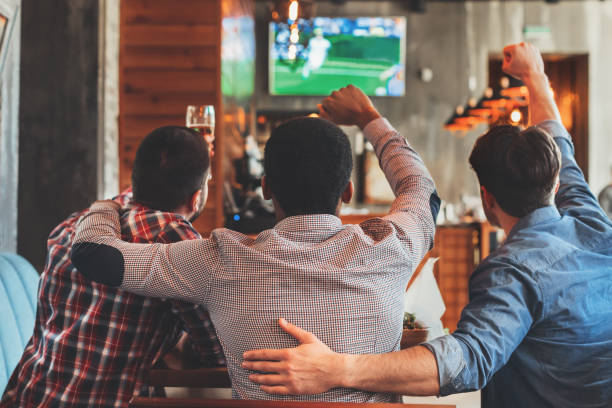 istock Three men watching football on TV in bar 1136617593