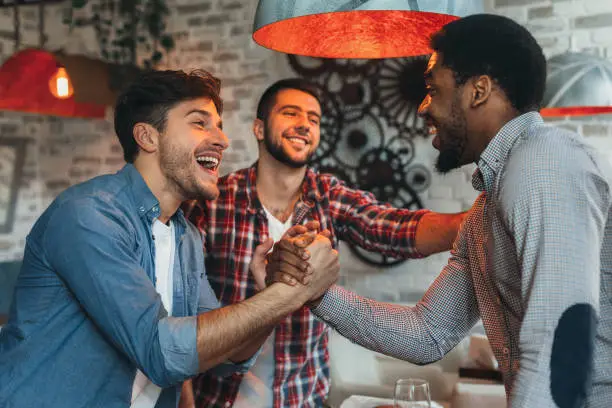 Photo of Old friends meeting. Three friends meet in pub