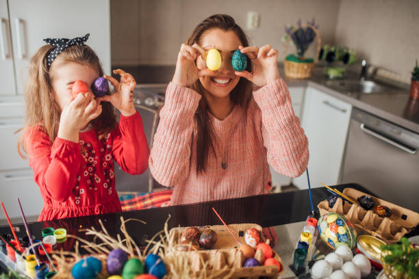 istock Woman and daughter holding colorful eggs 1136617850