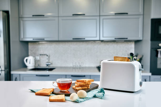 breakfast in the cozy kitchen. useful and tasty food. tea and toast in a toaster, eggs. - toaster imagens e fotografias de stock