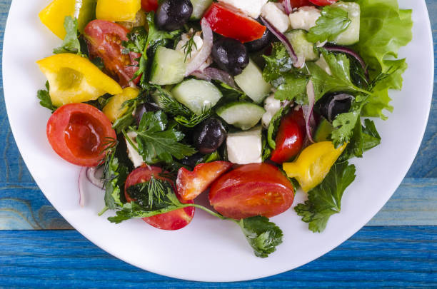 istock Vegetable salad cucumber capsicum tomatoes and olives on a white plate 1136620006