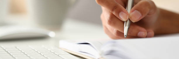 istock Female hand holding silver pen ready to make 1136624945