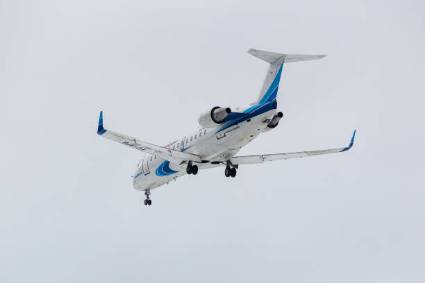 самолет bombardier crj-200lr (cl-600-2b19) вз-бпб авиак�омпании «ямал» приземлится в международном аэропорту домодедово в москве на фоне серого неба в пасм - 6002 стоковые фото и изображения