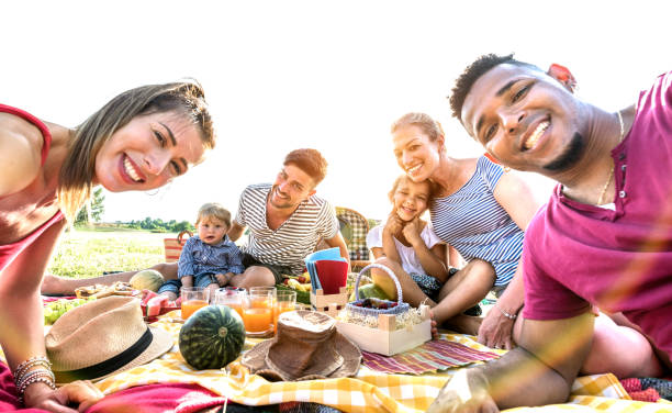feliz familias multirraciales tomando autofoto en pic nic fiesta de jardín - camping family vacations eating fotografías e imágenes de stock