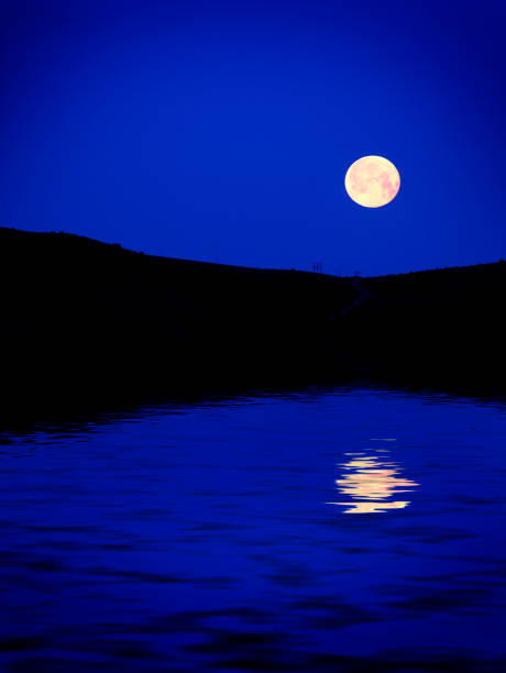 istock Moon rising over mountains at dusk blue light night time 1136629184