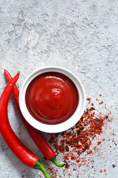 istock Spicy chili sauce with spices on a concrete background. View from above. 1136629737
