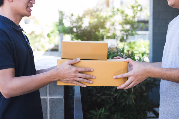 istock Delivery mail man giving parcel box to recipient, Young owner accepting of cardboard boxes package from post shipment, Home courier and delivery service mind concept 1136629758