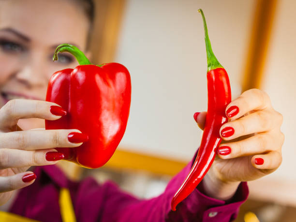 istock Woman holding bell pepper and chilli 1136631060