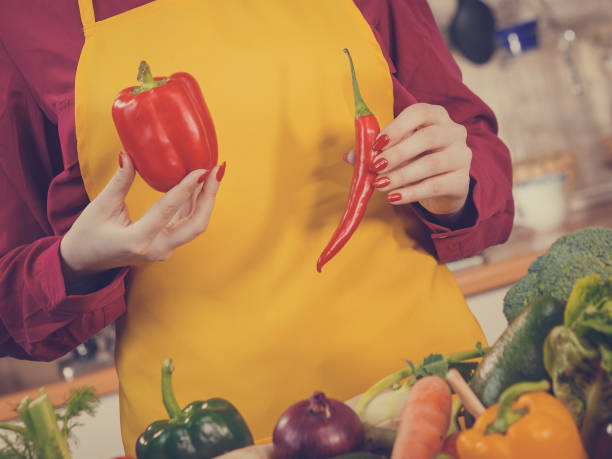 istock Woman holding bell pepper and chilli 1136631071