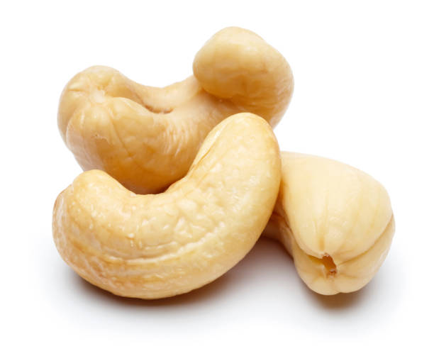 rohe cashewnüsse isoliert auf weiß - cashewnuss stock-fotos und bilder
