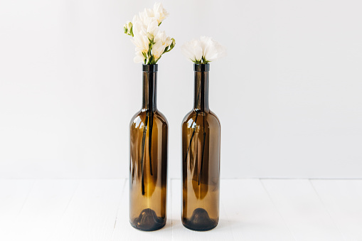 minimal composition of beautiful white flowers in bottles.copy space.white background.