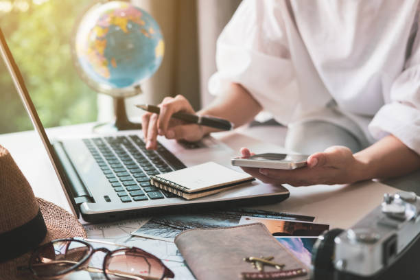 viajero joven planeando viaje de vacaciones y búsqueda de información o reserva de hotel en el ordenador portátil, concepto de viaje - hacer una reserva fotografías e imágenes de stock