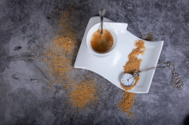 istock White porcelain coffee cup with brown sugar and pocket watch 1136635566