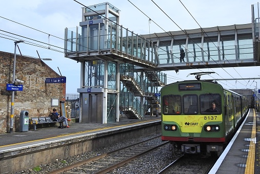 17th March, 2019, Dublin, Ireland. Blackrock Dart Station with train approaching under overhead walkway.