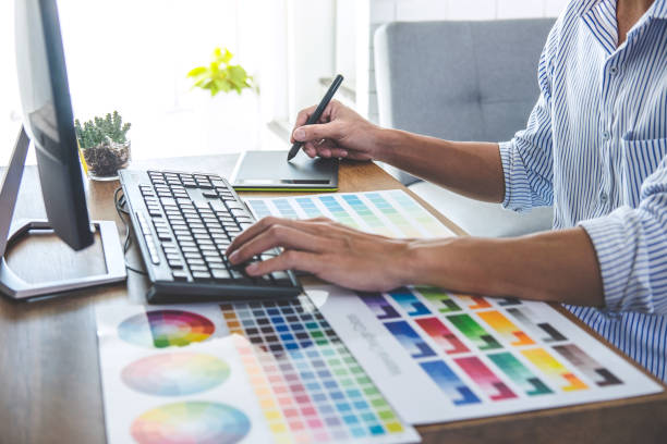 istock Image of male creative graphic designer working on color selection and drawing on graphics tablet at workplace with work tools and accessories in workspace 1136637497