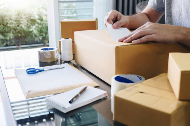 istock Young entrepreneur SME man receive order client and working with packaging sort box delivery online market on purchase order and preparing package product, Small business parcel for shipment 1136637527