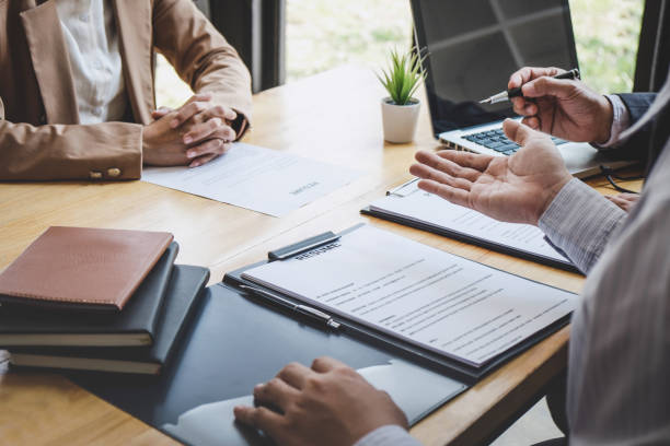 istock Two selection committee manager reading a resume during a job interview, Employer interviewing to ask young female job seeker for recruitment talking in office 1136637536